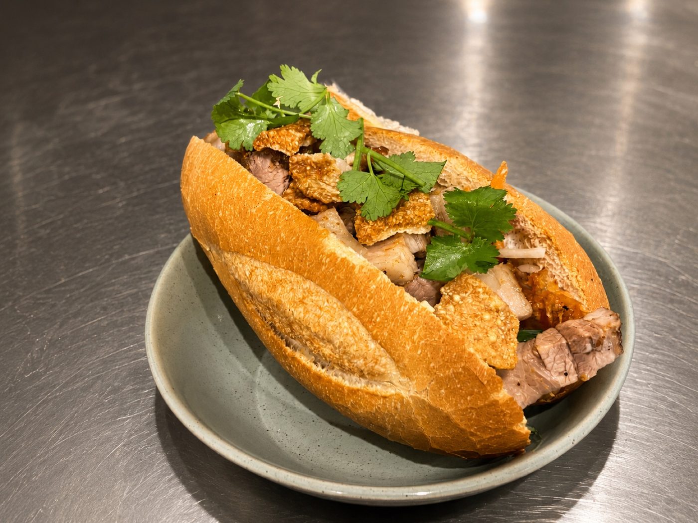 A filled bánh mì roll topped with fresh coriander on a plate at Asian Tucker in Tanunda