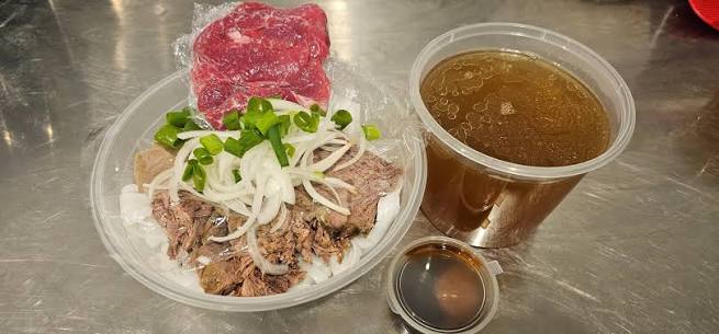 Phở packed to take away from Asian Tucker, with noodles, beef and onion in one container and the broth in a separate cup