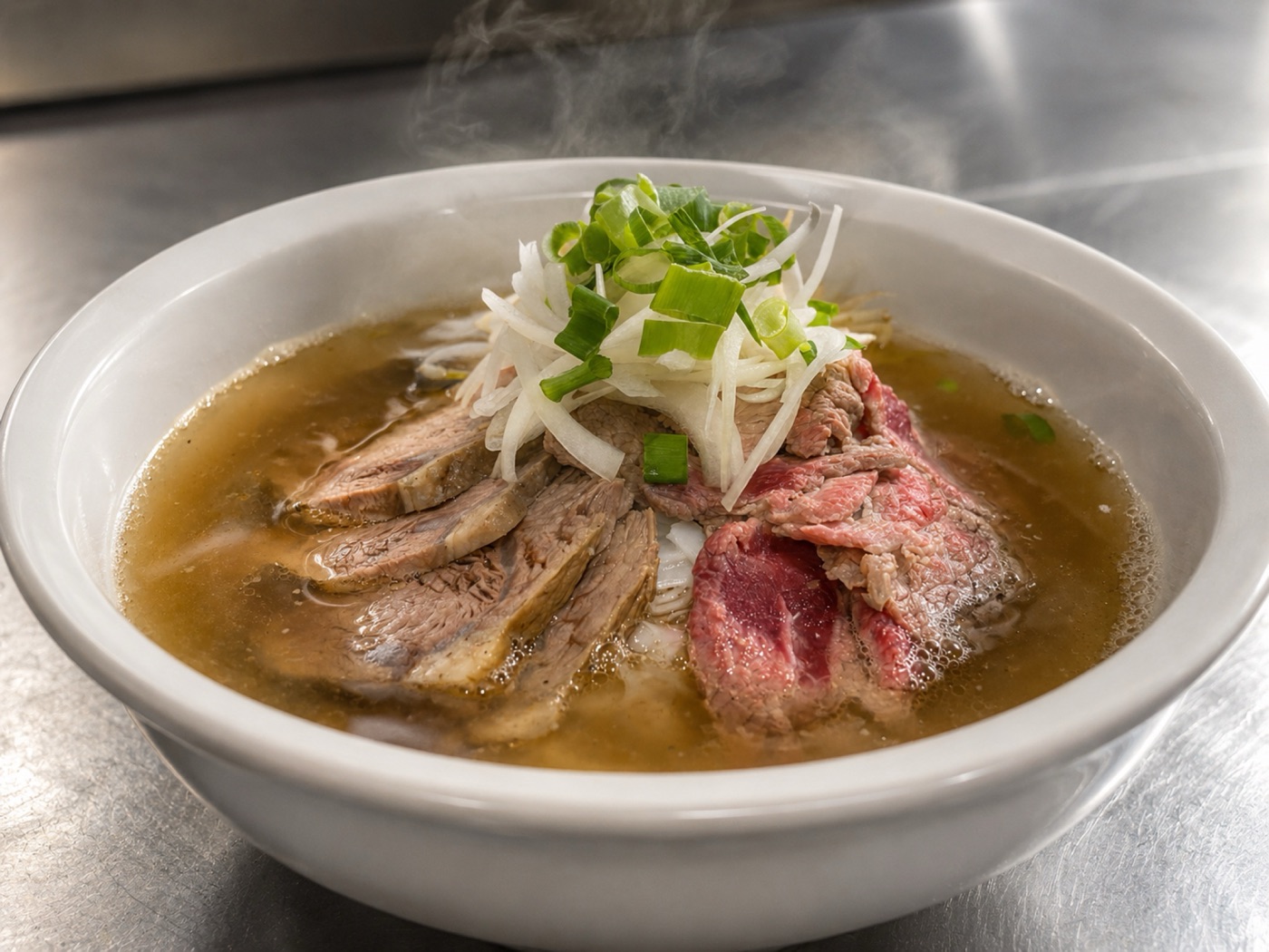 A bowl of beef phở at Asian Tucker in Tanunda, with sliced beef, onion and spring onion in a clear broth